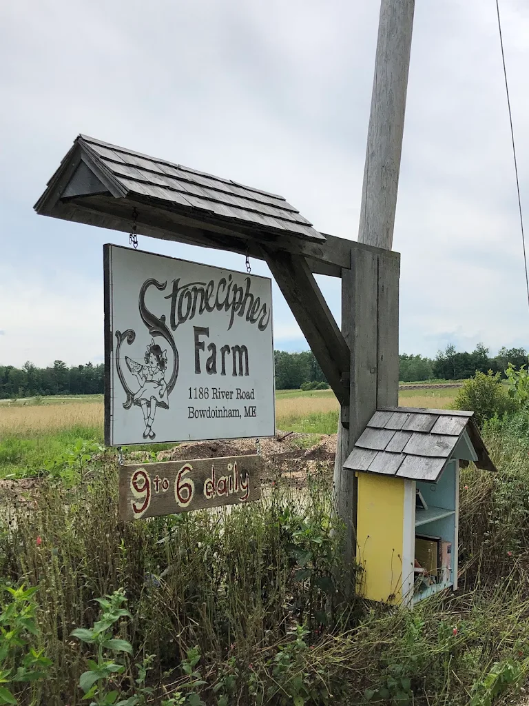 Rustic wooden farm sign beside a field